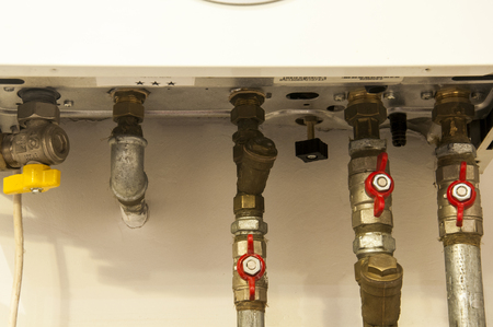 water and gas pipes coming from bathroom boiler heaterの写真素材