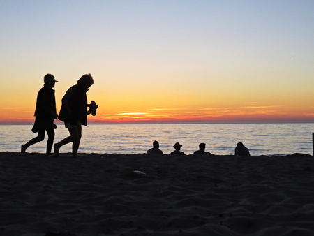 People Observing a Romantic Sunset at Sand Beach Seasideの写真素材