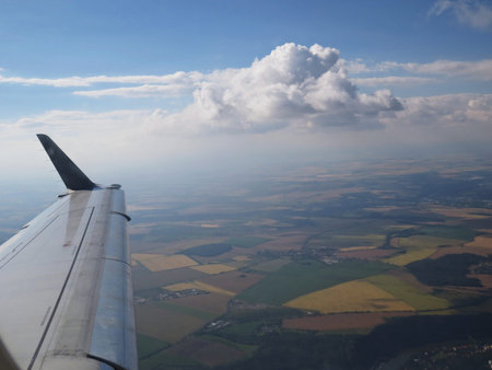 A Tranquil Beautiful View From Plane Window at Blue Sky over White Clouds with a Wing