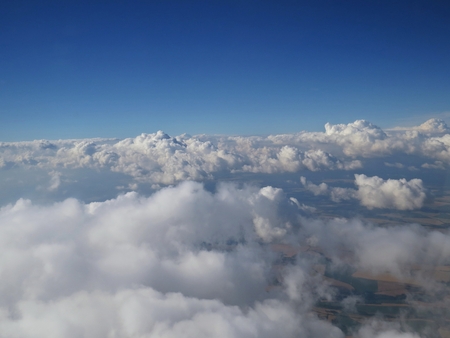 A Tranquil Beautiful View From Plane Window at Blue Sky over White Cloudsの写真素材