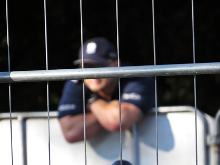 Fence with Policeman in the Background during Protests in front of the Polish Senate and Parliament, July 24, 2018, Warsaw, Polandのeditorial素材