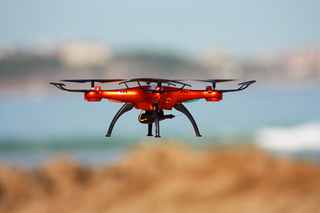 Flying drone with mounted camera on the beachの写真素材
