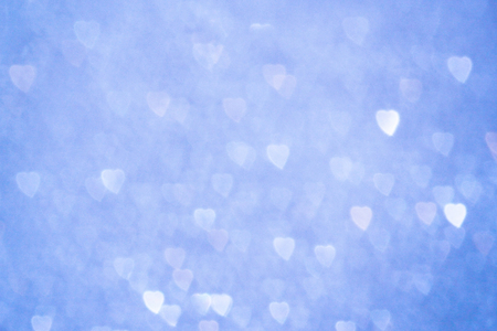 Bokeh blurred heart shape lights on the blue background. Valentines day theme.の写真素材