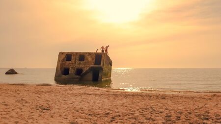 Teens are preparing to jump from a part of the old demolished forts in Liepaja, Latvia on the Baltic sea coastの写真素材
