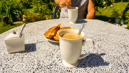 Healthy  morning breakfast in green garden at summer time. Served with two cups of coffee with milk...