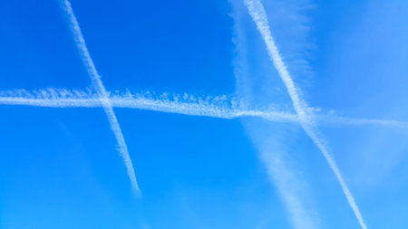 Condensation trails in a blue sky. Nature background.