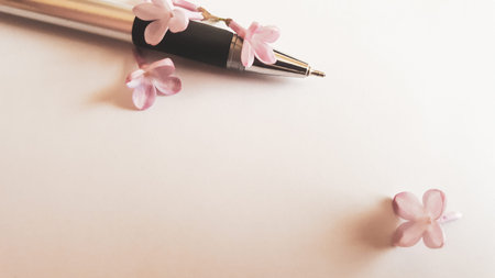 Spring lilac flowers and pen on pastel color paper background. Free space for Your text. Greeting card.の写真素材
