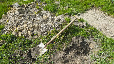 Shovel lying on green grass. Gardening tool. Seasonal work in the garden.の写真素材