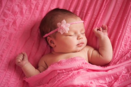 newborn baby girl wearing a pink flower headbandの写真素材