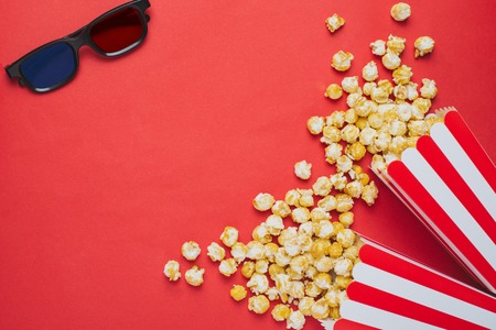 3D glasses and popcorn on a red background top viewの写真素材