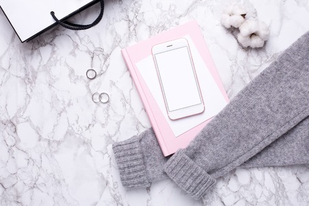 Women business day with mobile phone and pink notebook on marble table top viewの写真素材