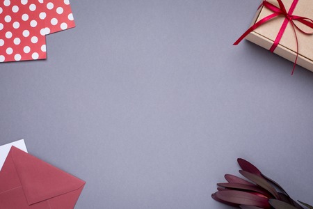 Gray background with gift envelopes and gift box top viewの写真素材