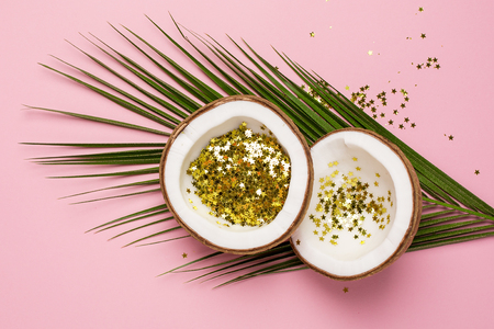 Coconut and palm with golden stars confetti on pink color paper background minimal styleの写真素材