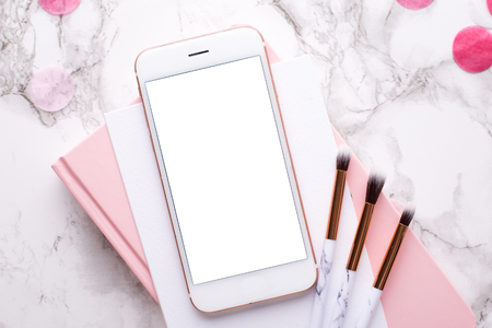 Cosmetic brushes and mobile phone on a marble backgroundの写真素材