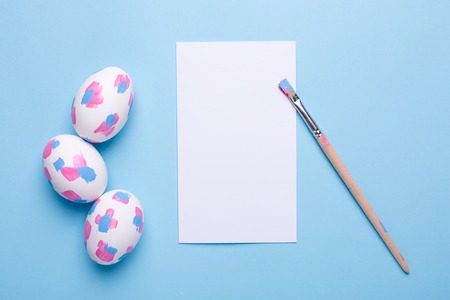 Card ,brush and easter eggs with watercolor brushstrokes top viewの写真素材