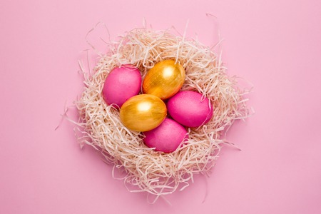 Easter pink and gold eggs on a pink background top viewの写真素材