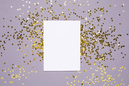 Golden stars confetti and white card on gray color paper background minimal style top viewの写真素材