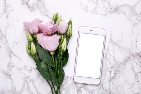 Mobile phone mock up with pink flowers on marble backgroundの写真素材