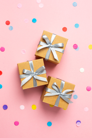 Gift or present boxes and color confetti on pink table. Flat lay composition for birthday, mother day or weddingの写真素材