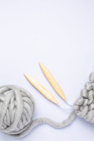 Knitting project in progress. A piece of knitting with ball of yarn and a knitting needles top view.