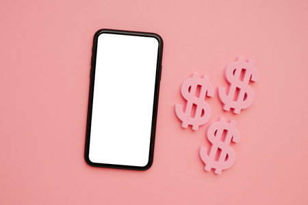 Mobile phone and American dollar symbol, money and technology flatlay top viewの写真素材