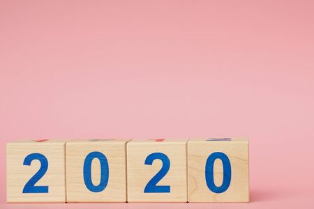 New year 2019 change to 2020 concept. Wooden block cube with number on pink tableの写真素材