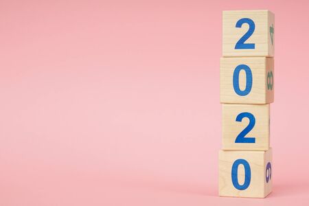 New year 2019 change to 2020 concept. Wooden block cube with number on pink backgroundの写真素材