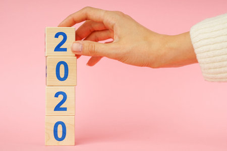 Wooden block cube with number New year 2020 on pink background