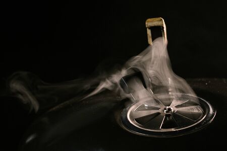 Hot grill for cooking with smoke on a black background side viewの写真素材