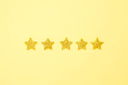 Brilliant glitter stars on a bright yellow background , rating 5 stars