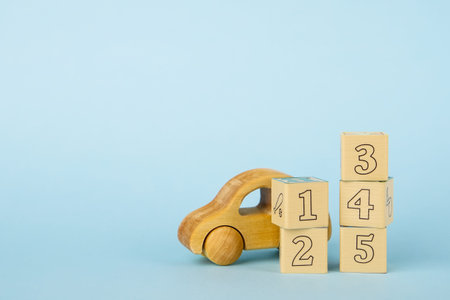 Blue background with colored cubes with numbers and toy car side view, baby development and toys for...