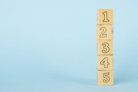 Wooden childrens cubes on a blue background side view, early childhood development and education
