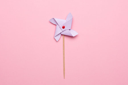 Blue paper windmill pinwheel isolated on pink background top view, Circus, Childhood, Festival,...