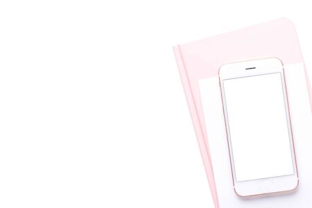 Mobile phone with a pink notebook on a white background top viewの写真素材