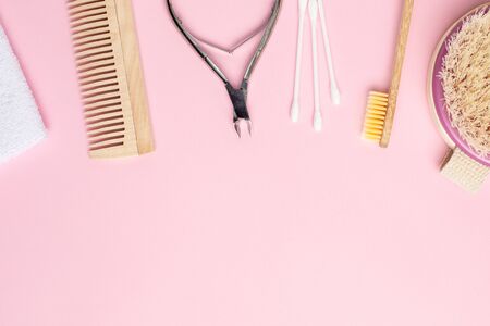Pink background with wooden toothbrush , comb and nippers , bathroom and spa accessoryの写真素材