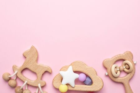Baby wooden rattles and toys on pink background isolated with copy space top viewの写真素材