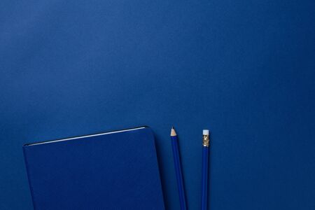 Blue office notebook and pencil on a classic blue background with copyspace. Trendy color 2020の写真素材