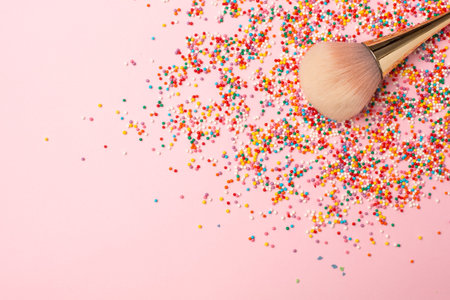 Makeup brush and multicolored round confetti with copyspace. Colorful beauty background.