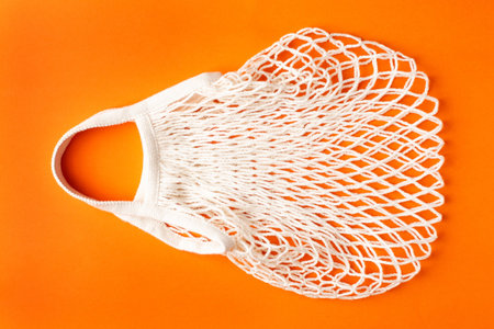 Cotton shopping eco friendly bag on orange background, zero waste and plastic free concept.