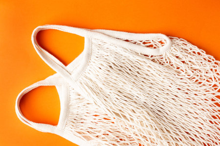 Cotton shopping eco friendly bag on orange background, zero waste and plastic free concept op view.