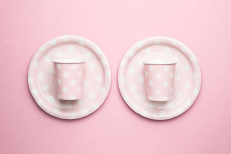 Polka dot disposable paper cups and plates on pink backgroundの写真素材