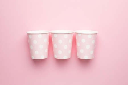 Polka dot disposable paper cups on pink background top viewの写真素材