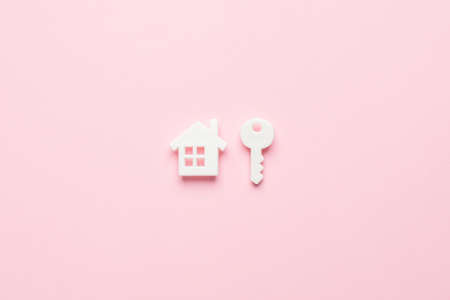 White house and key symbol in a minimal style on a pink backgroundの写真素材