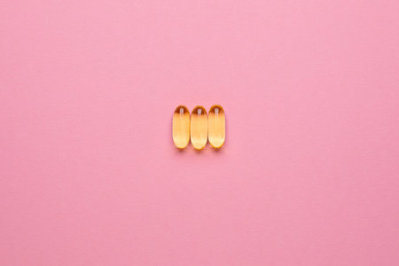 Vitamins Omega 3 6 9 fish oil , vitamin D on a pink background for health lifestyle with copyspace