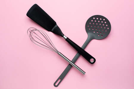 Kitchen accessories spatula whisk on a pink background, female cooking top viewの写真素材