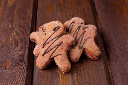 Gingerbread man cookies with chocolate on a wooden background top viewの写真素材