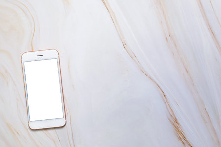 Flat lay Smartphone with blank white screen and copy-space on marble table. Elegant Design with...