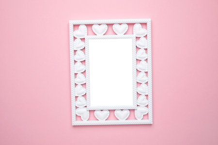 Valentine's Day composition. Photo frame with hearts on pastel pink background. Wedding. Birthday....
