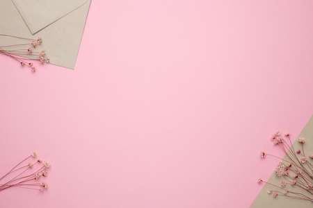 Light beige envelope ans dry flower branchon on pink background. Delicate panorama and trend, minimal dried concept background top viewの写真素材