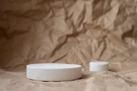White geometric shapes podium for product display on craft paper background. Monochrome stage, stand for product promotionの写真素材